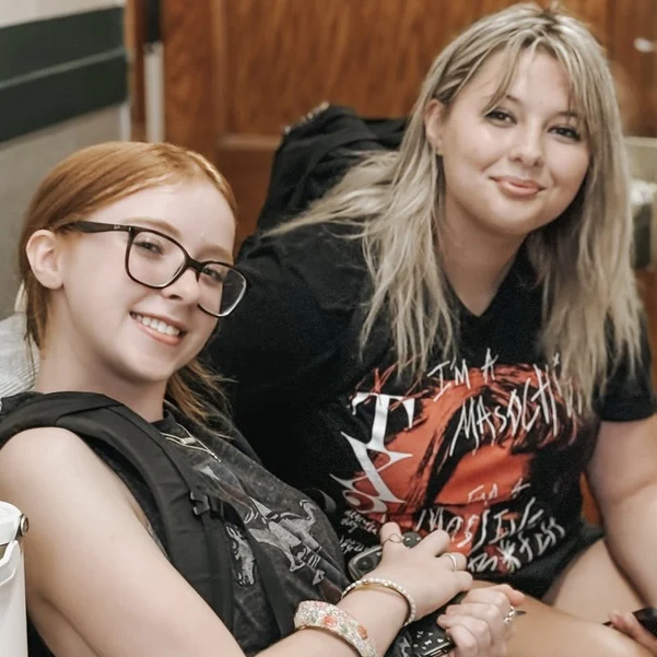 Two students sitting together and smiling at the camera